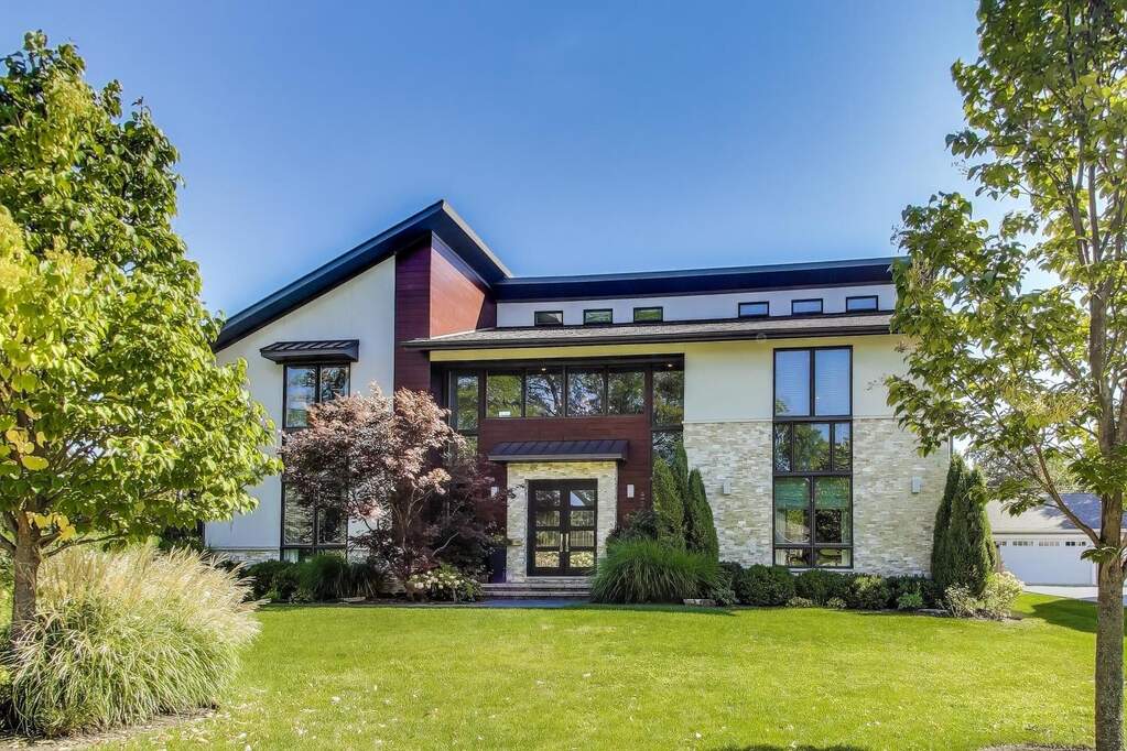 Modern house with large windows and trees.