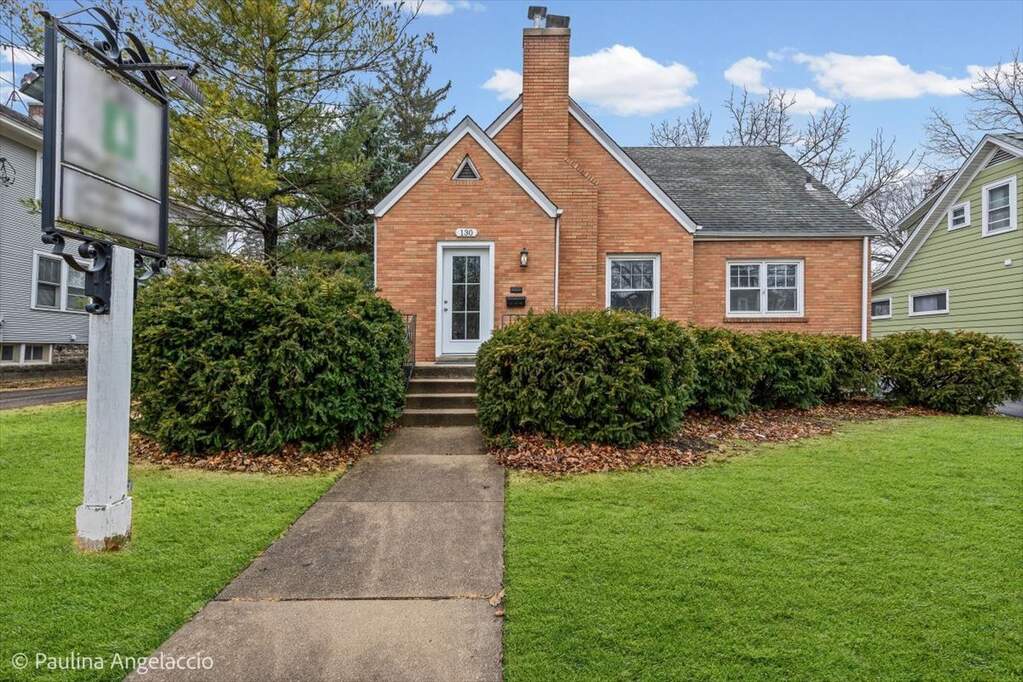 Brick house with path and green lawn.