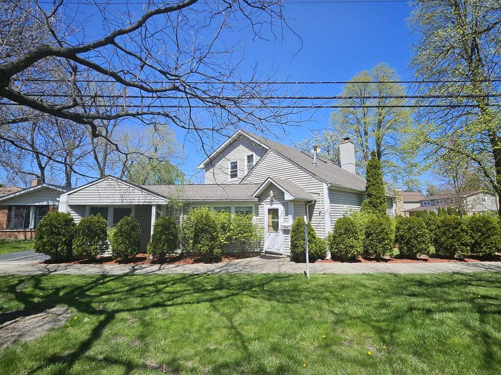 Suburban house with trees and shrubs.