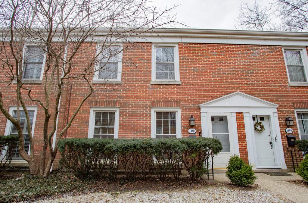 Brick townhouse with white trim and wreath.