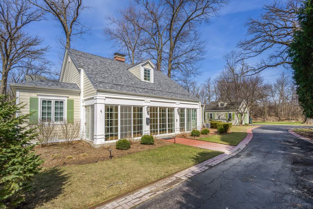 Charming house with large windows and driveway.