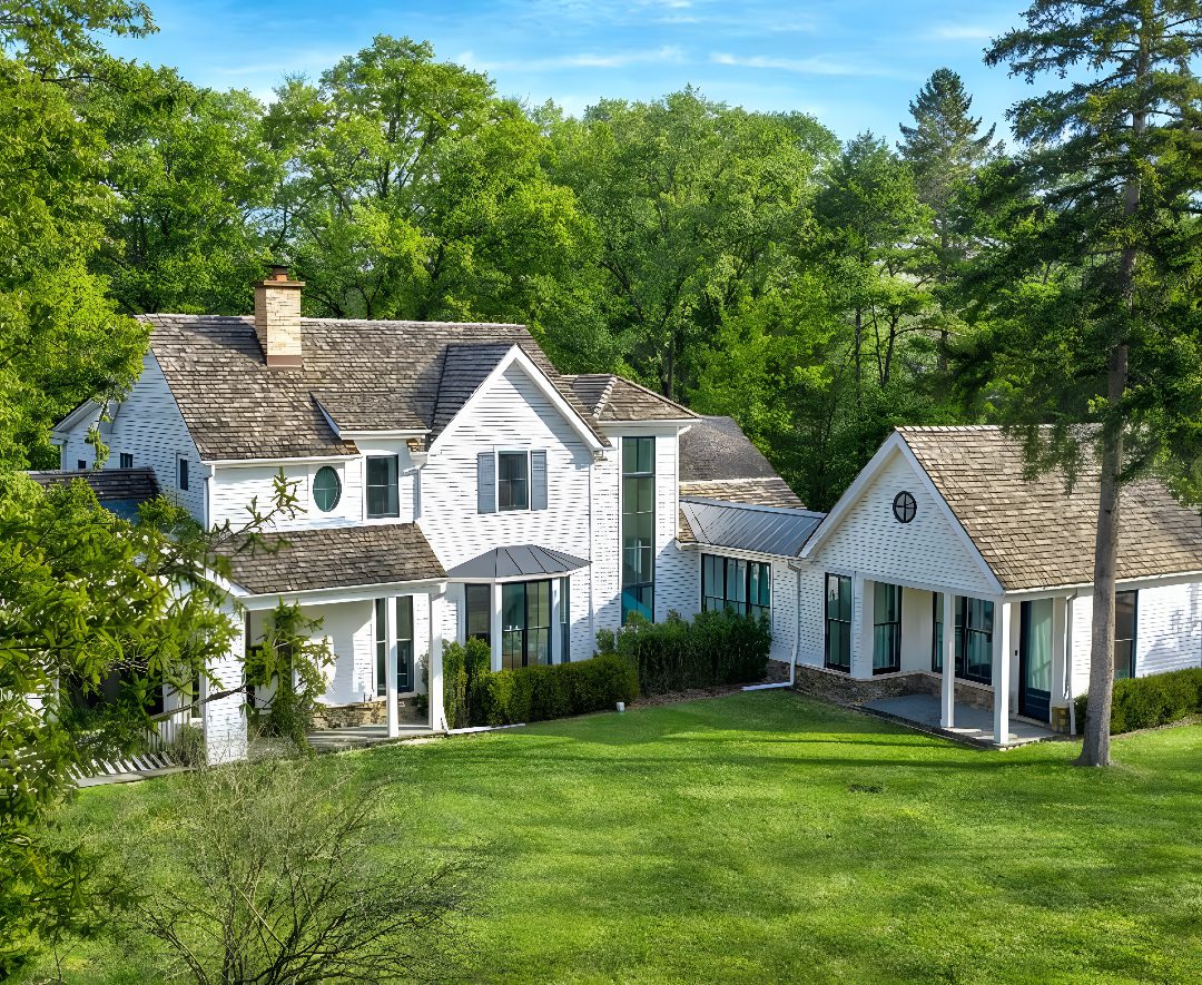 White house surrounded by lush green trees.