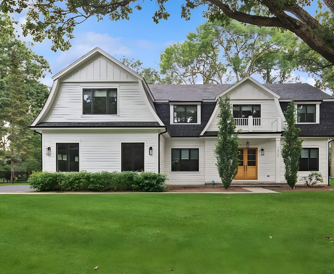 Modern white house with green lawn.